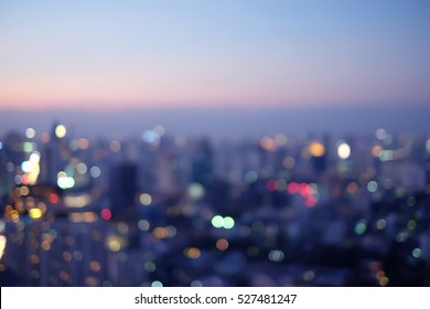 Abstract Blurred Sky Night City Building Of Downtown Construction With Circle Round Light Background With Lens Flare Effect.