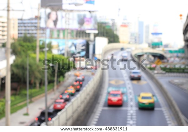abstract blurred of traffic in the evening. It\
is going to rain : blur of vehicles cars,saloon,bus,motorcycle,\
people at the road, Bangkok,\
Thailand.
