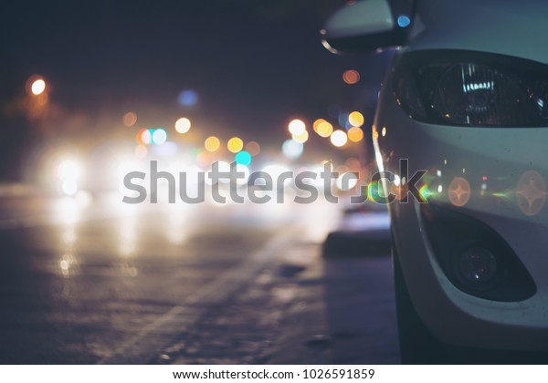  abstract blurred white car\
and lamp on the road with abstract light bokeh in the night\
background