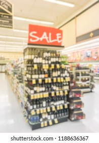 Abstract Blurred Wine Aisle With Sale, Discount Sign At Grocery Store In Texas, America. Defocused Row Of Red, White Wine Liquor Bottles And Price Tags On Supermarket Shelf. Alcoholic Beverage Concept