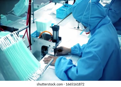 Abstract, blurry, out of focus image for media and internet. The concept of control and prevention with the coronavirus growing epidemic in the world. Production of antivirus masks. - Shutterstock ID 1665161872