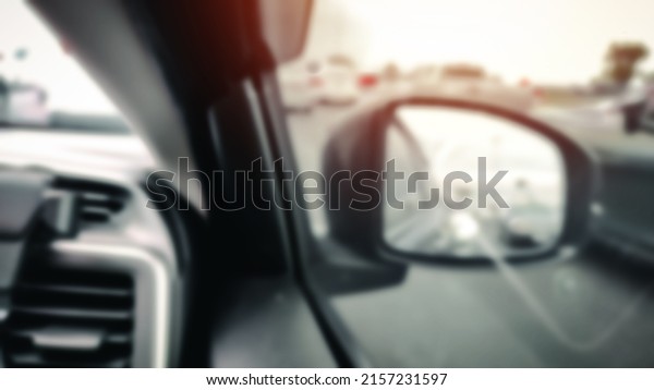 Abstract blurry The reflection of\
car mirror. Rear view mirror reflection. Concept of Transportation\
and safety Car driving on the road. View of driver in the\
car.