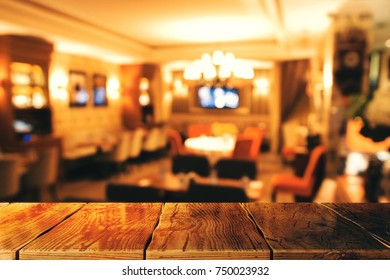 Abstract blurry restaurant interior texture with empty wooden table. Mock up
