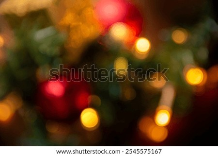 Abstract bokeh image featuring blurred Christmas lights and vibrant red and gold ornaments, creating a warm and festive atmosphere ideal for holiday-themed projects.