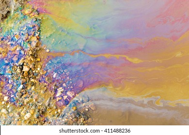 Abstract of bright vibrant oil spill shapes of pollution on the surface of water. Patterns of multi-coloured pollutants releasing hazardous chemicals into the environment.