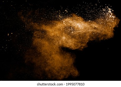 Abstract Brown Dust Explosion On Black Background.Brown Powder Splashing.