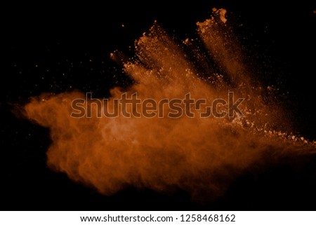 Abstract brown powder splatted background. Colorful powder explosion on black background. Colored cloud. Colorful dust explode. Paint Holi.
