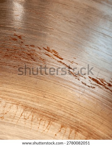 Abstract brushed metal surface with rust stains, scratches and industrial texture detail. Weathered metallic background with warm copper and steel tones.