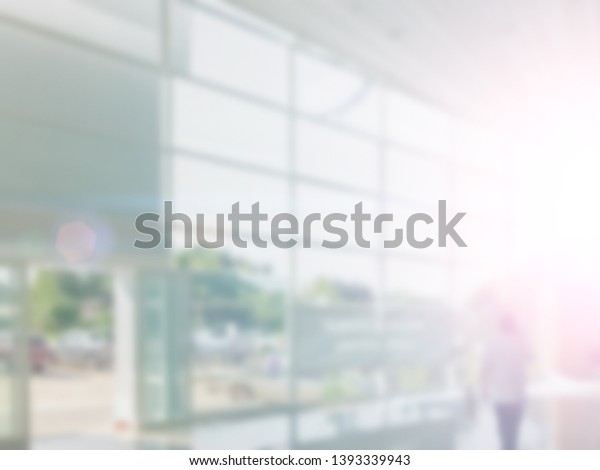 Abstract building or car showroom lobby\
hall blur background of shallow office depth of focus with blurry\
workplace interior and empty entrance, glass windows, floor and\
exterior light\
illumination.