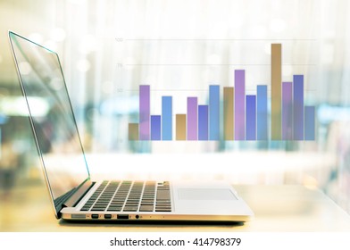 Abstract Business Background Laptop With Financial Graph And Blur Light