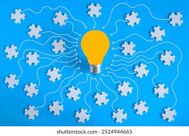 Abstract business concept,collaboration,cooperation,teamwork makes the dream work, innovation,human resources,recruitment,team building.Jigsaw puzzle pieces and lightbulb on blue background. - Powered by Shutterstock