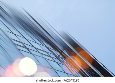 Abstract business modern city urban futuristic architecture background. Real estate concept, motion blur, reflection in glass of high rise skyscraper facade, toned blue picture with bokeh