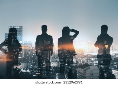 Abstract businesspeople silhouettes working together on dark city skyline backdrop. Teamwork, colleagues and communication concept. Double exposure - Powered by Shutterstock