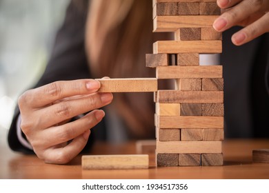Abstract businesswomen fail danger tower block game building construction protect plan and project control.