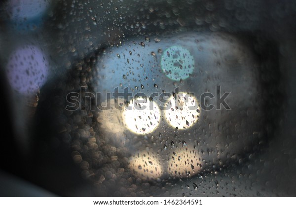 Abstract car\
window on a rainy day, viewed from the seat in the car, blurred\
background , rain in the car window, blurred rain in the car\
window, driving light in rainy\
weather