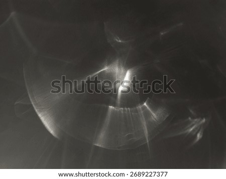 Abstract caustic light patterns created by refraction and reflection on a transparent surface.
Soft flowing lines and glowing shapes form a dynamic play of light and shadow.