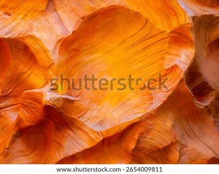 Abstract cave wall texture, orange color background. Scene of wonderful lower stone canyon with smooth movement, curving line and texture, light and shade formation.