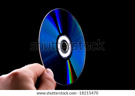 abstract cd dvd blue-ray disk in hand isolated on black