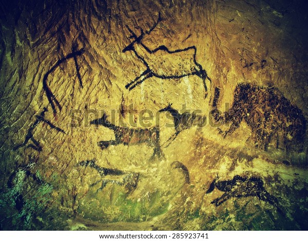 Abstract children art in cave. Black carbon paint of\
human hunting on sandstone wall, copy of prehistoric\
picture.Prehistoric drawings in cave. Bison, mammoth, deer,\
caveman. Primitive neanderthal\
art