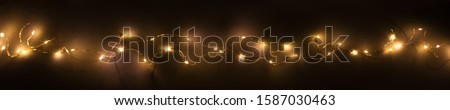Abstract christmas led lights on dark  background. Blurred glowing light bulb garland,  layer for screen mode overlays to light up the bulbs. Festive concept banner