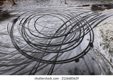 Abstract circles in snow, car drift skid marks on winter road race track.