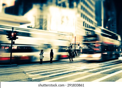 Abstract Cityscape Blurred Background, Art Toning. Night View Of Modern City Street With Moving Transport, Illuminated Skyscrapers And Walking People. Hong Kong