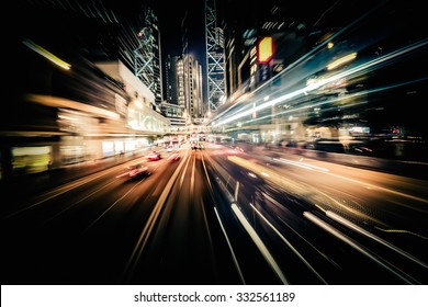 Abstract cityscape traffic background with motion blur, art toning. Moving through modern city street with  illuminated skyscrapers. Hong Kong - Shutterstock ID 332561189