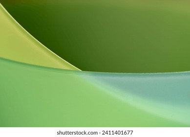 Abstract close up of overlapping green and yellow translucent plastic bowls