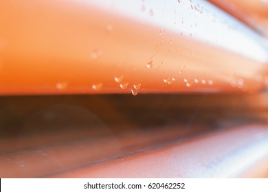 Abstract close up of a stack of orange plastic pipes on construction with water drops for plumbing