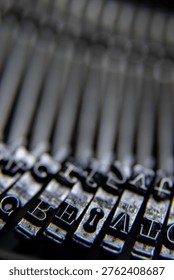 Abstract close up of typewriter typebars and characters with shallow depth of field and soft blur.