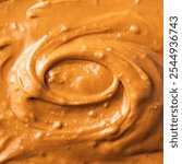 Abstract close-up of creamy peanut butter texture with swirling patterns