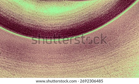 An abstract close-up features a granular surface with shimmering textures and a vibrant curved line separating deep maroon and light greenish-beige tones.