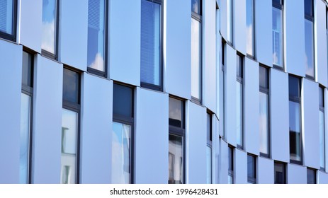 Abstract Closeup Of The Glass-clad Facade Of A Modern Building Covered In Reflective Plate Glass. Architecture Abstract Background. Glass Wall And Facade Detail.