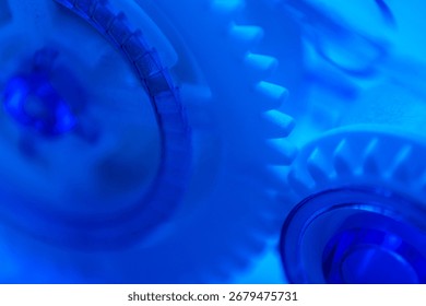 Abstract close-up of interlocking white gears illuminated with blue light, emphasizing innovation, mechanics, and technology.