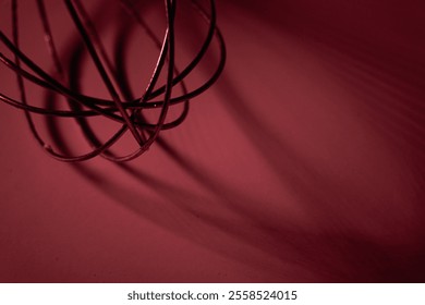 Abstract close-up of a kitchen whisk in red lighting, highlighting shadows and wire details. Ideal for creative designs - Powered by Shutterstock