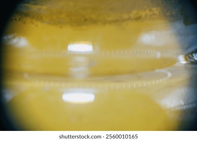 Abstract close-up of liquid in a container with markings. Reflections and textures create a unique, scientific or industrial feel. - Powered by Shutterstock