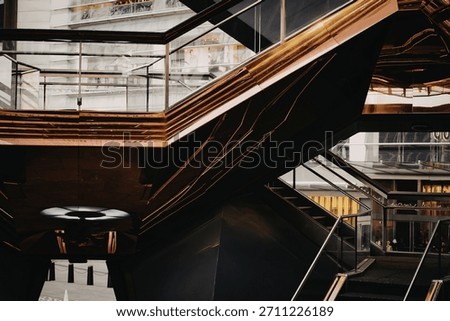 An abstract close-up of a metallic, angular structure featuring layered surfaces and reflective qualities, creating a sense of depth and complexity.