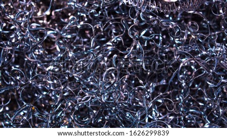 Abstract color background of metal shavings. Processing of ferrous and non-ferrous metals in a factory or plant. Metal background. Colored shavings. Wallpaper or screensaver of colored metallic chips