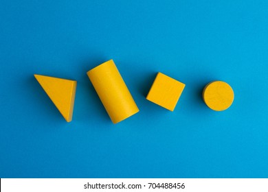 Abstract Color Composition With Yellow Wood Toy Building Blocks On Blue Paper Background