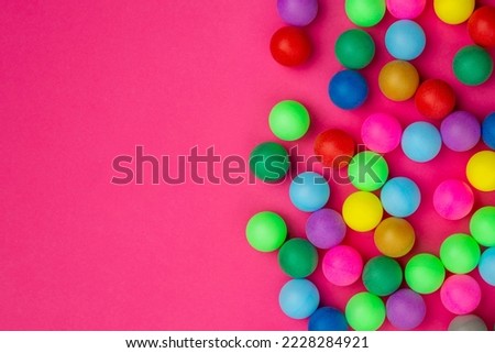 Abstract colored balls background. Multi-colored taw toy scattered on bright paper. Base for design nice backdrop, wallpaper, poster. Noisy surface texture.