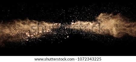 Abstract colored brown powder explosion isolated on black background. High resolution texture