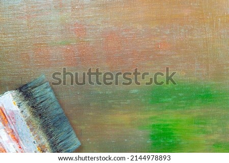 abstract colored creative background - rough linen canvas unevenly covered with multi-colored primers, reflections of light, wide brush. Toning, blur. Temporary object. 