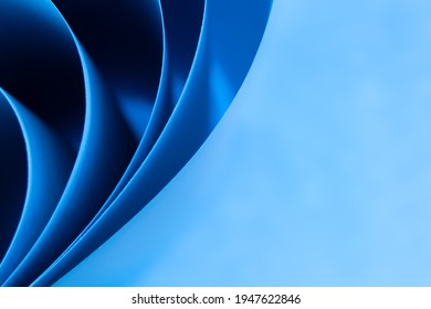 Abstract colored macro background, created with curved blue paper sheets. Curved lines and shapes and soft vivid colors.