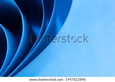 Abstract colored macro background, created with curved blue paper sheets. Curved lines and shapes and soft vivid colors.