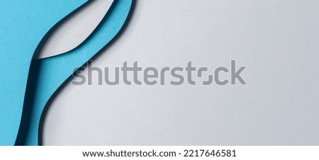 Abstract colored paper texture background. Minimal paper cut style composition with layers of geometric shapes and lines in blue hue colors. Top view.