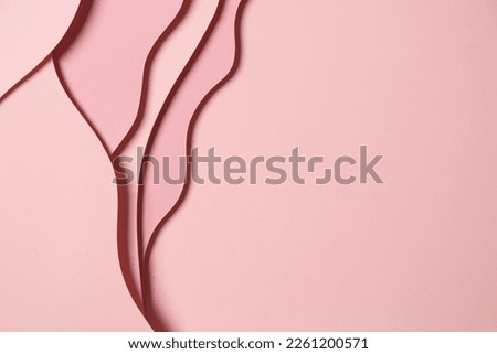 Abstract colored paper texture background. Minimal paper cut composition with layers of geometric shapes and lines in pastel pink colors. Top view, copy space