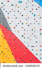 Abstract Colorful Of Rock Climbing Wall With Toe And Hand Hold Studs.