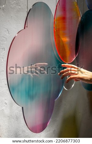Abstract colourful cloud pattern light refraction with hand and white background. Colourful light and shadow light effect stock photo
