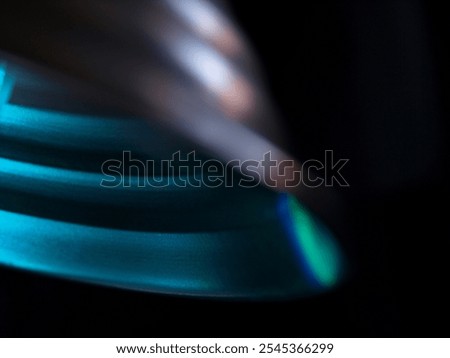 Abstract colourful light pattern with layered rings in blue and teal hues. Modern and futuristic design with vibrant gradient reflections and soft texture.