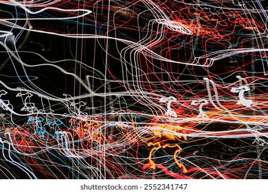 Abstract composition of colorful light trails in red, white, and blue against a black background. The chaotic patterns create a dynamic and energetic visual perfect for artistic or conceptual designs.